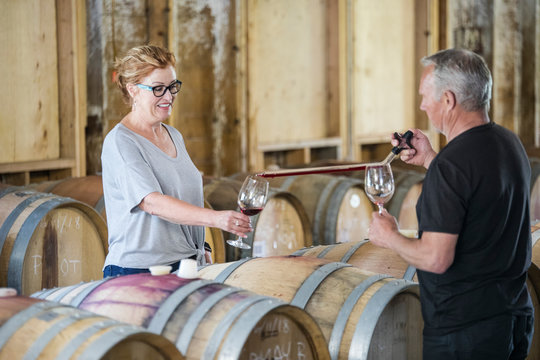 sommelier uses pipette to pour sample glass of wine to investor.