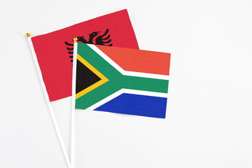 South Africa and Albania stick flags on white background. High quality fabric, miniature national flag. Peaceful global concept.White floor for copy space.