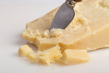 Trancio e scaglie di formaggio su sfondo bianco