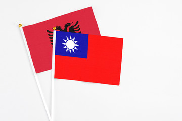 Taiwan and Albania stick flags on white background. High quality fabric, miniature national flag. Peaceful global concept.White floor for copy space.