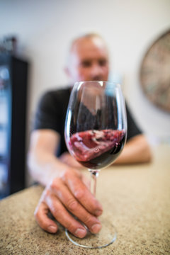 Man swirling a glass of red wine during a wine tasting.