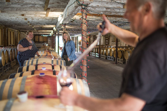 winemaker pouring wine for two ladies during wine tasting tour.