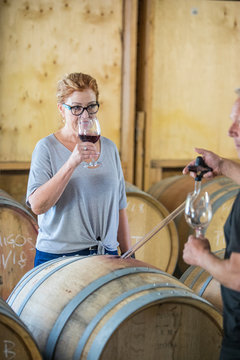 sommelier uses pipette to pour sample glass of wine to investor.