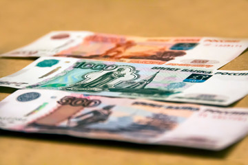 Banknotes of the Russian currency of different denominations scattered on the table - a sign of wealth and prosperity.