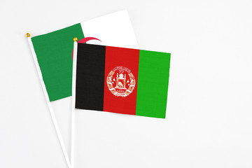 Afghanistan and Algeria stick flags on white background. High quality fabric, miniature national flag. Peaceful global concept.White floor for copy space.