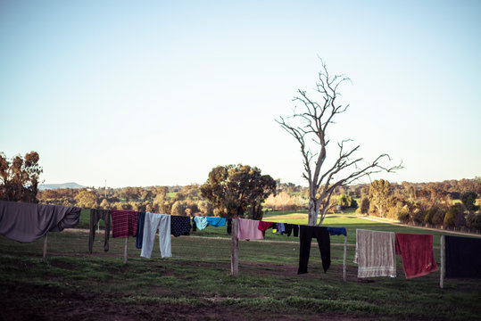 clothes dry on fence line as sun sets on farm land in Austalia