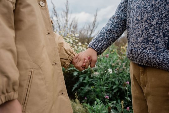 close up of children holding hands outside