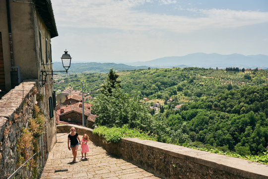 Mother and daughter walking along idyllic rural street