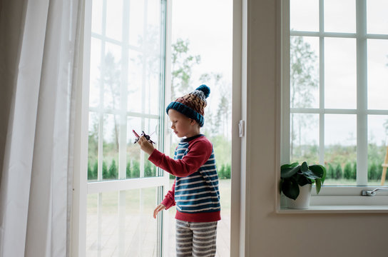 young boy playing with aeroplane in the doorway at home