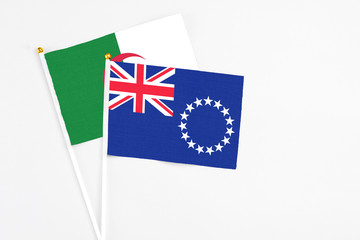 Fototapeta premium Cook Islands and Algeria stick flags on white background. High quality fabric, miniature national flag. Peaceful global concept.White floor for copy space.