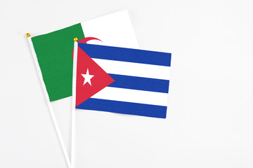 Cuba and Algeria stick flags on white background. High quality fabric, miniature national flag. Peaceful global concept.White floor for copy space.