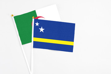Curacao and Algeria stick flags on white background. High quality fabric, miniature national flag. Peaceful global concept.White floor for copy space.