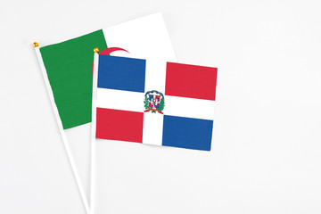Dominican Republic and Algeria stick flags on white background. High quality fabric, miniature national flag. Peaceful global concept.White floor for copy space.