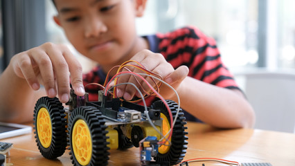 Concentrated boy creating robot at lab.