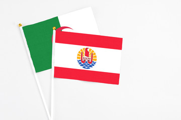 French Polynesia and Algeria stick flags on white background. High quality fabric, miniature national flag. Peaceful global concept.White floor for copy space.