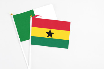 Ghana and Algeria stick flags on white background. High quality fabric, miniature national flag. Peaceful global concept.White floor for copy space.