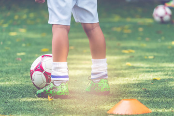 Little boy is standing on a soccer field with football on his feet © junce11