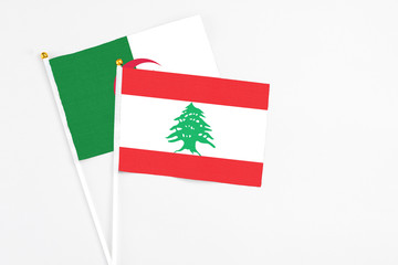 Lebanon and Algeria stick flags on white background. High quality fabric, miniature national flag. Peaceful global concept.White floor for copy space.