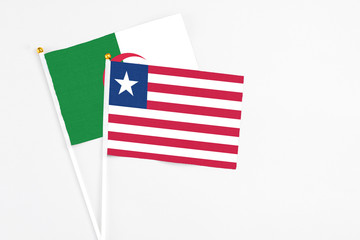 Liberia and Algeria stick flags on white background. High quality fabric, miniature national flag. Peaceful global concept.White floor for copy space.