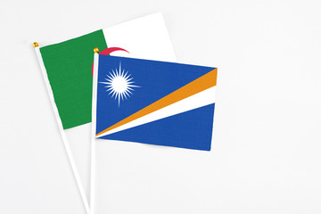 Marshall Islands and Algeria stick flags on white background. High quality fabric, miniature national flag. Peaceful global concept.White floor for copy space.