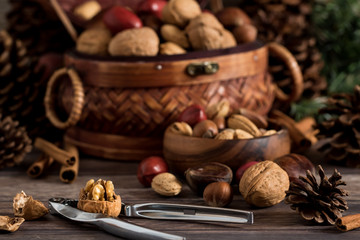 Heaping basket of mixed nuts with small bowl.
