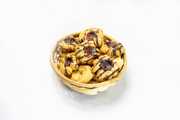 fresh cookies in a straw basket on a white background
