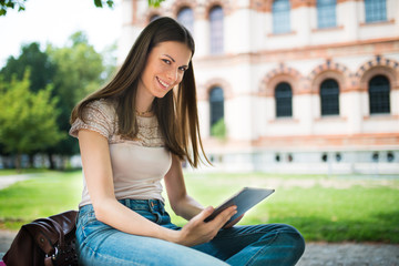 Obraz premium Female student studying in a park in front of the school