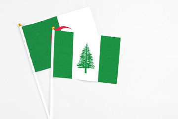 Norfolk Island and Algeria stick flags on white background. High quality fabric, miniature national...