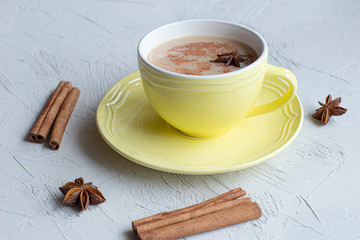 cup of masala tea with cinnamon sticks and anice star in a blue mug 