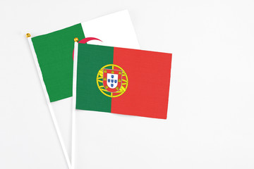 Portugal and Algeria stick flags on white background. High quality fabric, miniature national flag. Peaceful global concept.White floor for copy space.