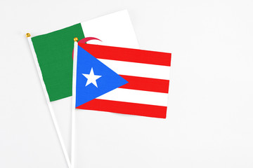 Puerto Rico and Algeria stick flags on white background. High quality fabric, miniature national flag. Peaceful global concept.White floor for copy space.