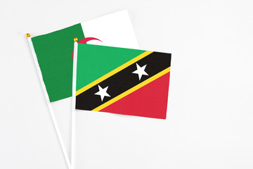 Saint Kitts And Nevis and Algeria stick flags on white background. High quality fabric, miniature...