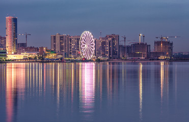 Fototapeta premium Novo-Savinovsky City District, Kazan, Russia. Evening lights reflected on waterface