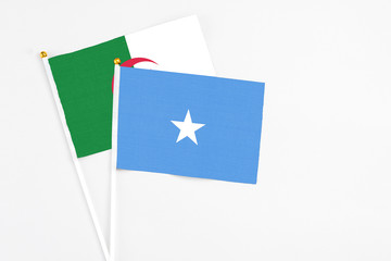 Somalia and Algeria stick flags on white background. High quality fabric, miniature national flag. Peaceful global concept.White floor for copy space.