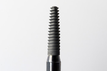 medium-sized dental implant for tooth and root restoration on a white background