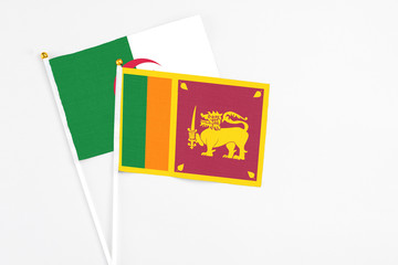 Sri Lanka and Algeria stick flags on white background. High quality fabric, miniature national flag. Peaceful global concept.White floor for copy space.