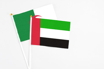 United Arab Emirates and Algeria stick flags on white background. High quality fabric, miniature national flag. Peaceful global concept.White floor for copy space.