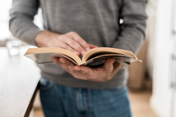 Close-up of man reading book at home