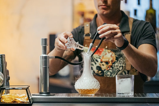 Bartender Mixing Cocktail In A Bar, Decanter With Steam