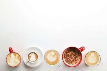 Buch of coffee cups with different kind of beverage and different latte art foam designs. Top view, close up, copy space, background.