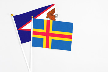 Aland Islands and American Samoa stick flags on white background. High quality fabric, miniature...