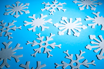 Winter background of thick 3-D snowflakes on a bright blue background