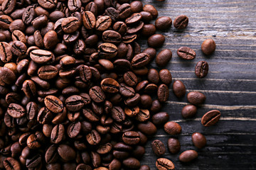 Roasted brown coffee beans scattered on wood textured table with a lot copy space for text. Flat...