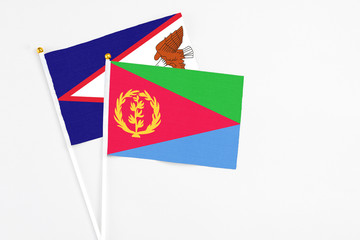 Eritrea and American Samoa stick flags on white background. High quality fabric, miniature national flag. Peaceful global concept.White floor for copy space.
