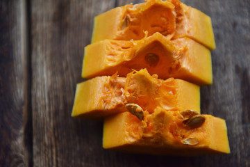 ripe orange pumpkin sliced on a wooden table