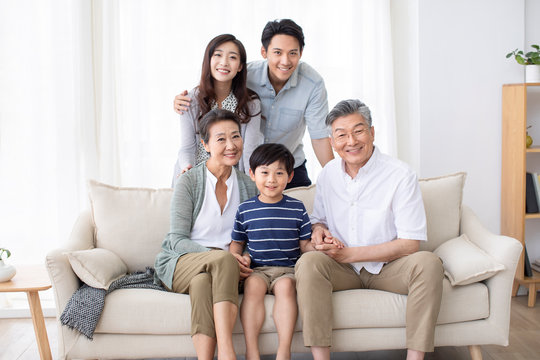 Happy Chinese family relaxing on sofa