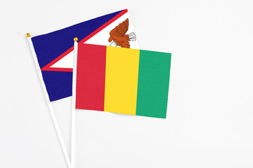 Guinea and American Samoa stick flags on white background. High quality fabric, miniature national...