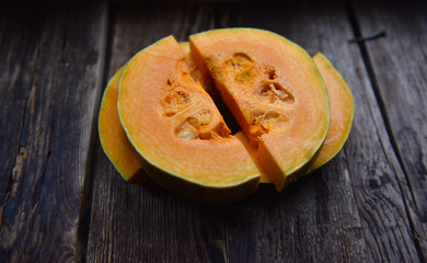 ripe orange pumpkin sliced on a wooden table