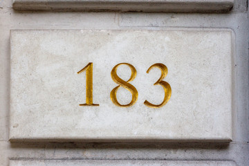 House number 183 carved in stone and lettered in gold
