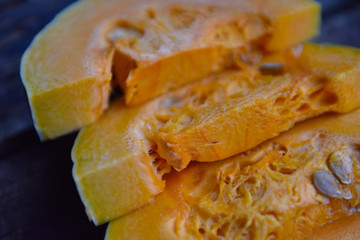 ripe orange pumpkin sliced on a wooden table